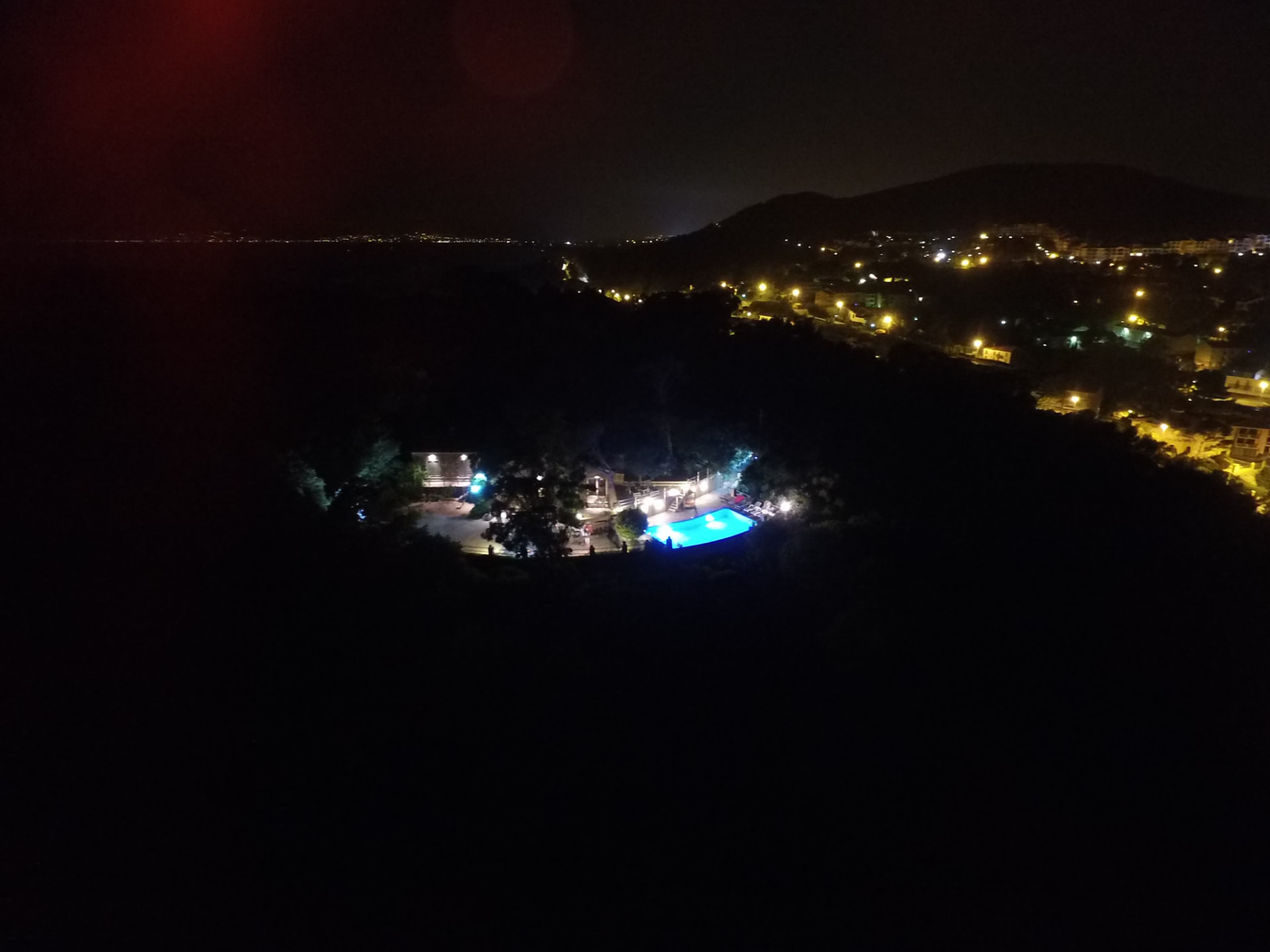 Vue nocturne de la propriété et de sa piscine éclairée