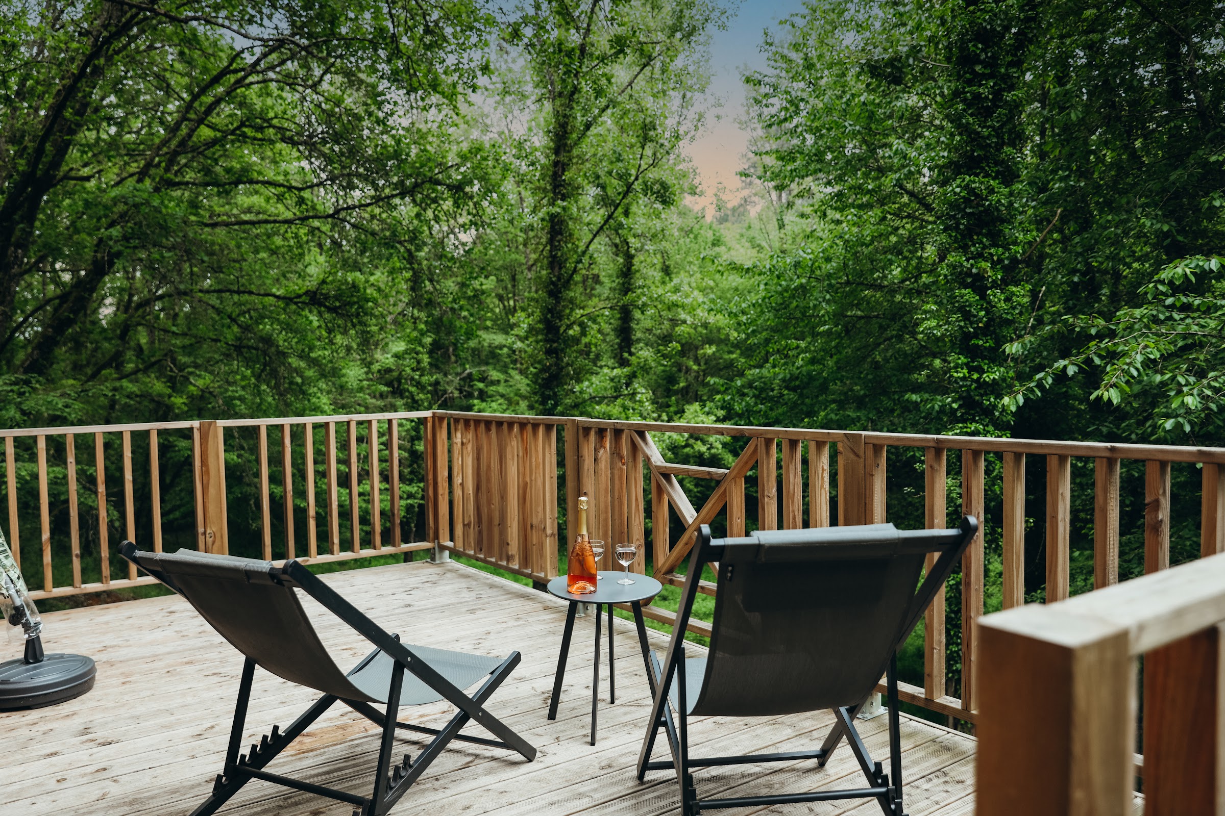 Vue de la maisonnette de pierre entourée de chênes et de verdure