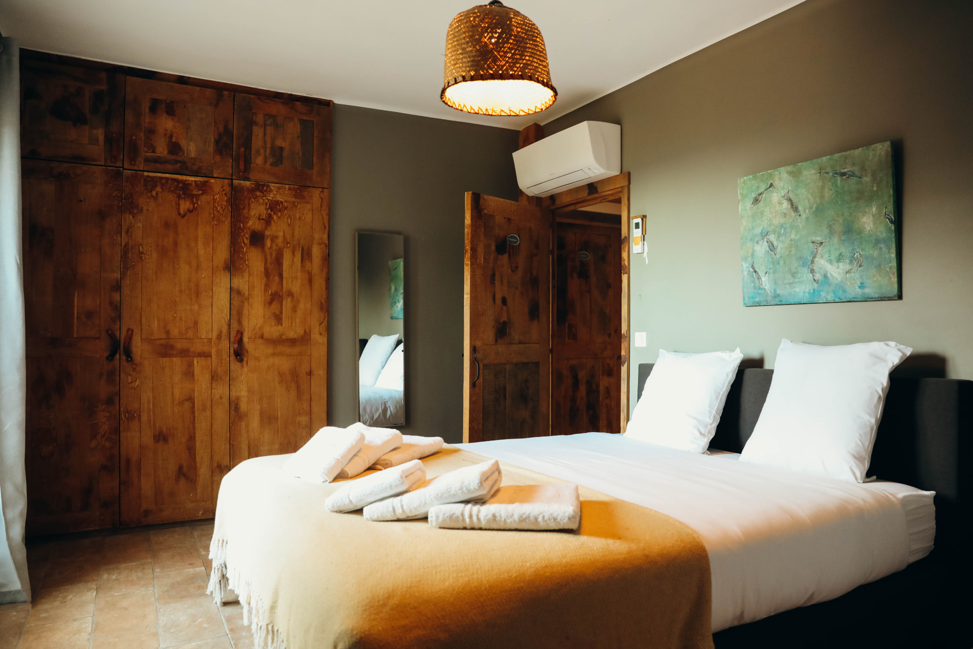 Chambre aux armoires en bois ancien et linge blanc