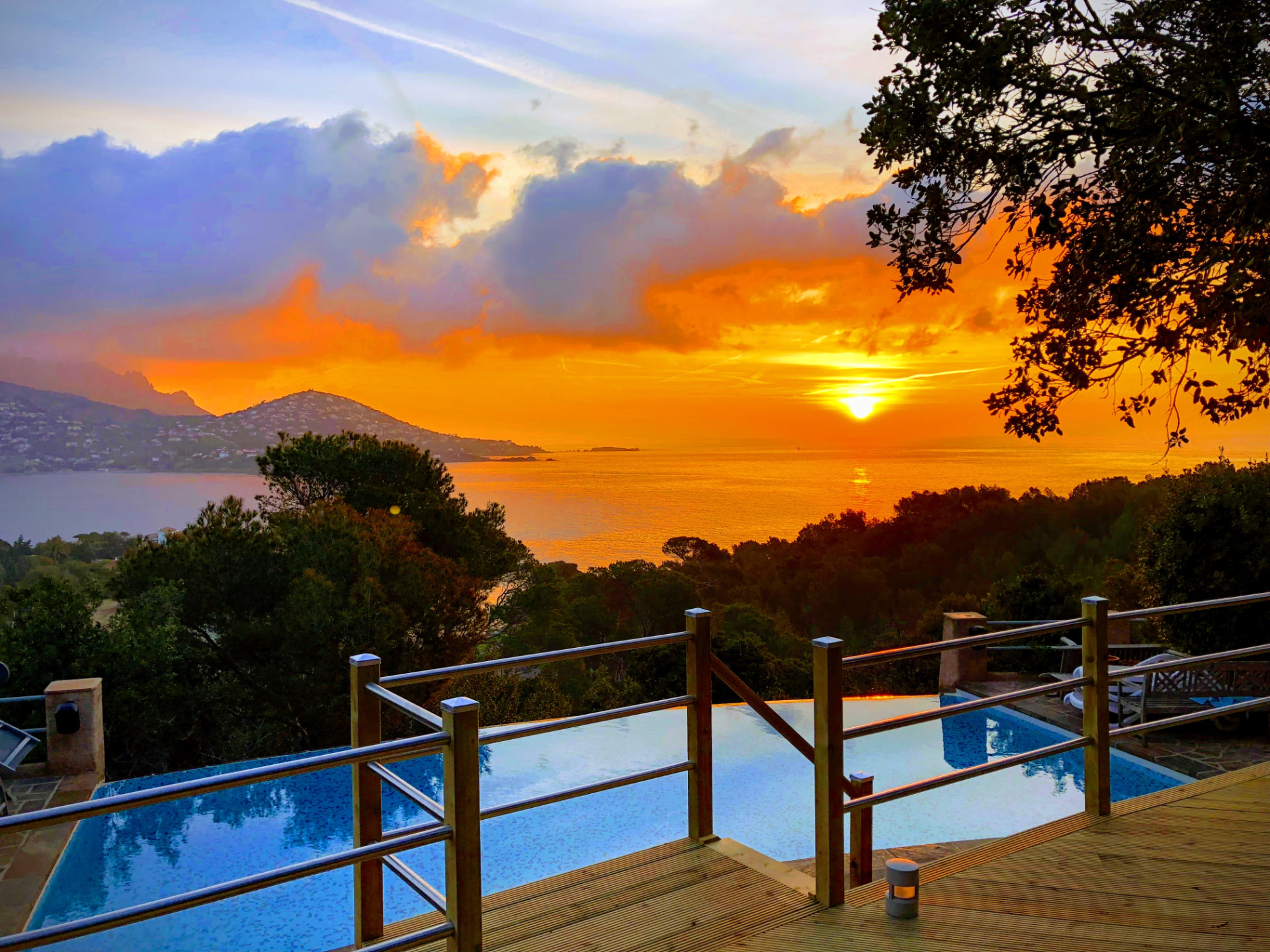 Coucher de soleil embrasé sur la baie depuis la piscine